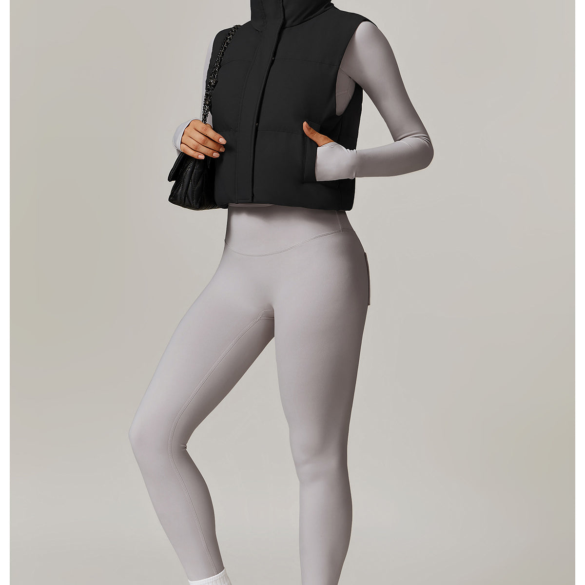 Woman in black puffer vest and gray leggings showcasing Winter Fashionable Warm Vest Coat for stylish ملابس and langry fashion