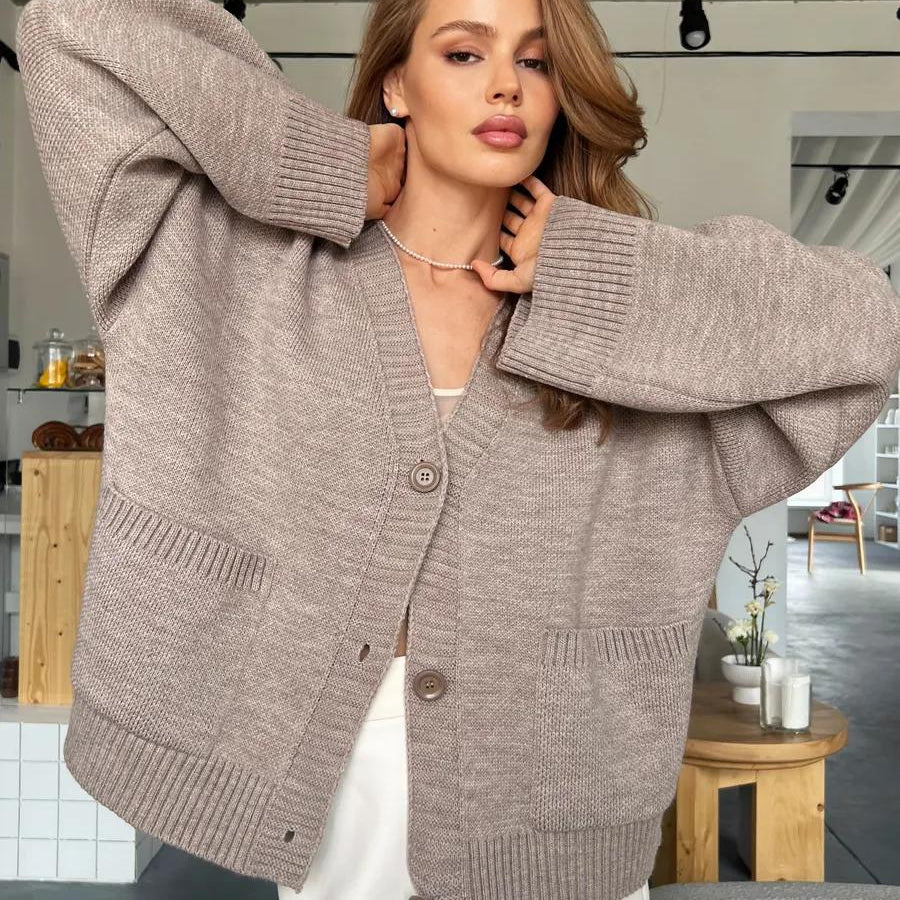 Beige oversized knitted cardigan with ribbed detailing and soft design button closure