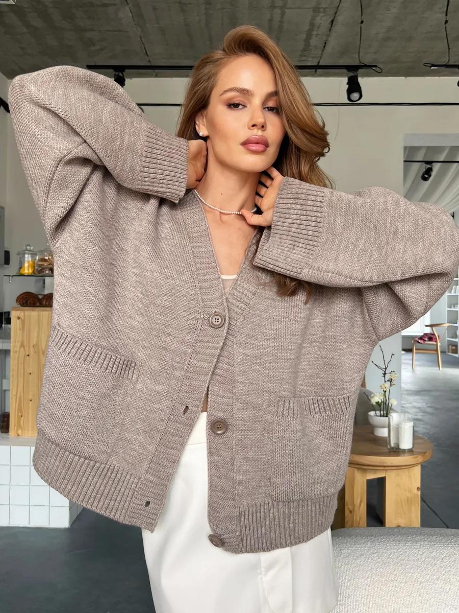 Beige oversized knitted cardigan with ribbed detailing and soft design button closure