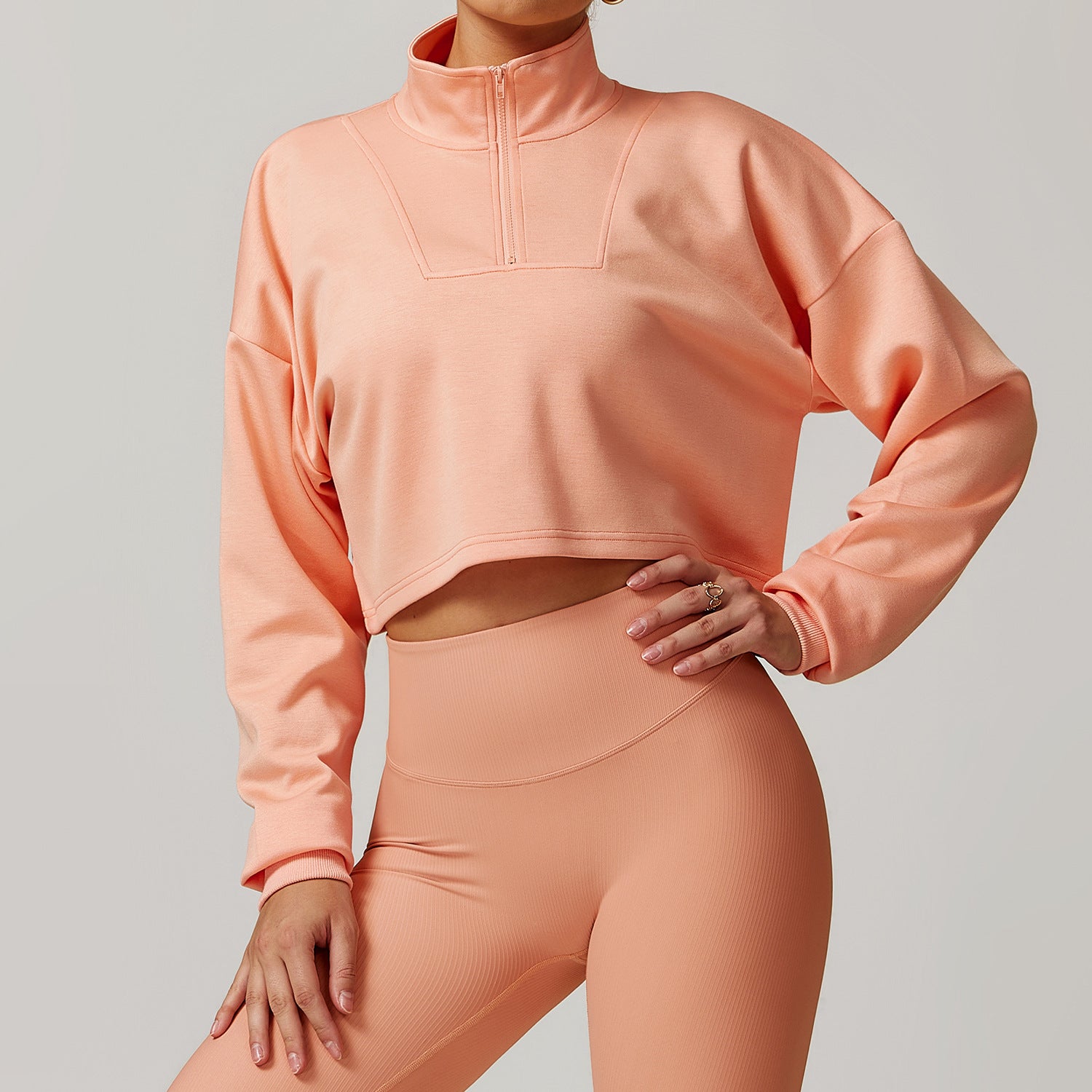 Peach-colored cropped athletic pullover and high-waisted leggings from Winter Wild Outerwear