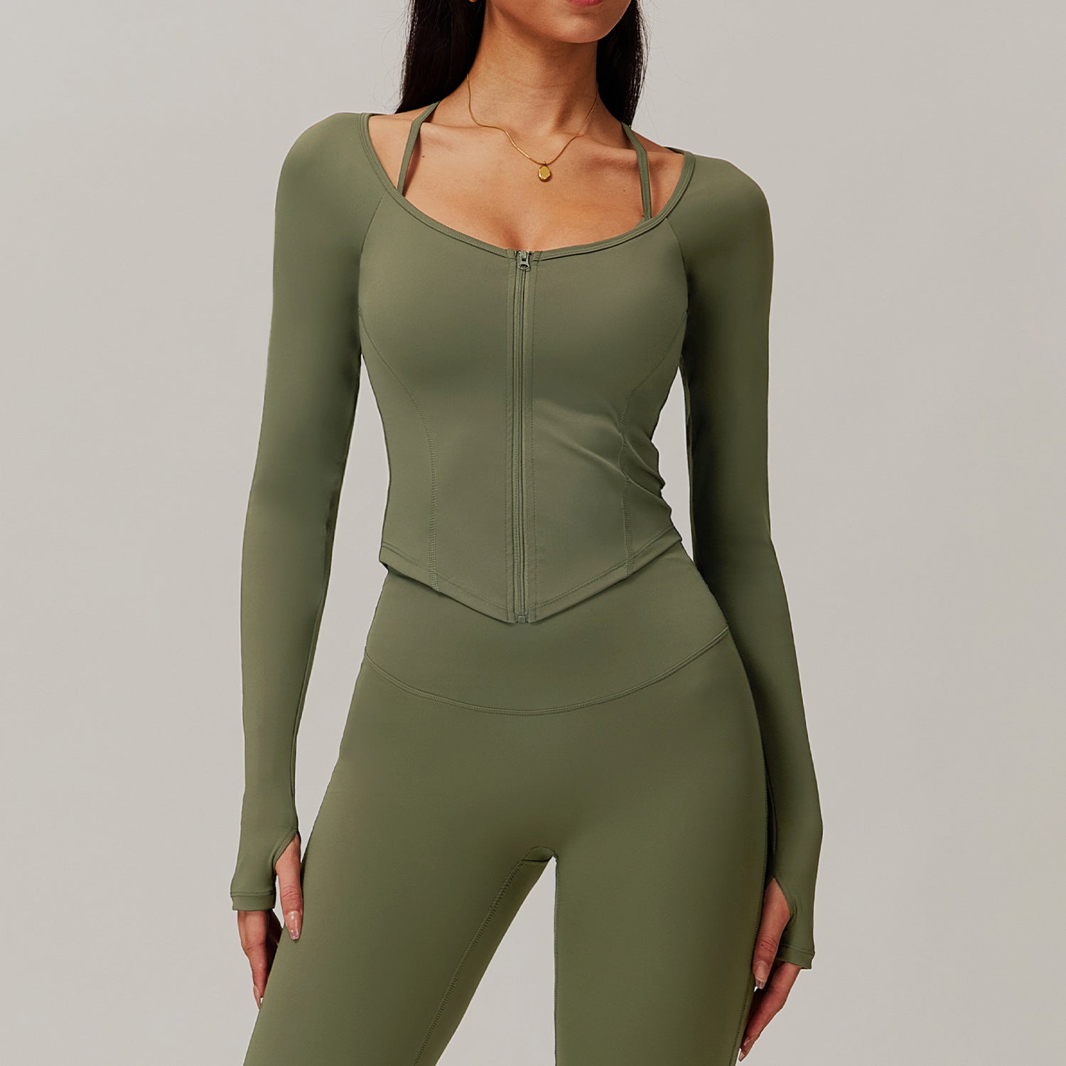 Olive green workout set featuring a long-sleeved zip-front top and fitted leggings ملابس
