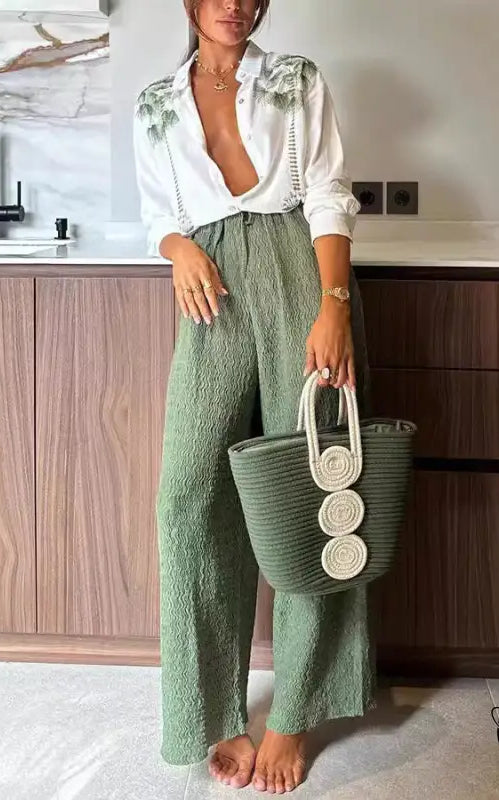 Woman in printed long-sleeved single breasted trousers suit with green tote bag
