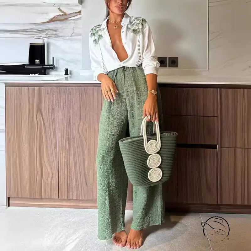 Woman in printed long-sleeved single breasted trousers suit with green tote bag