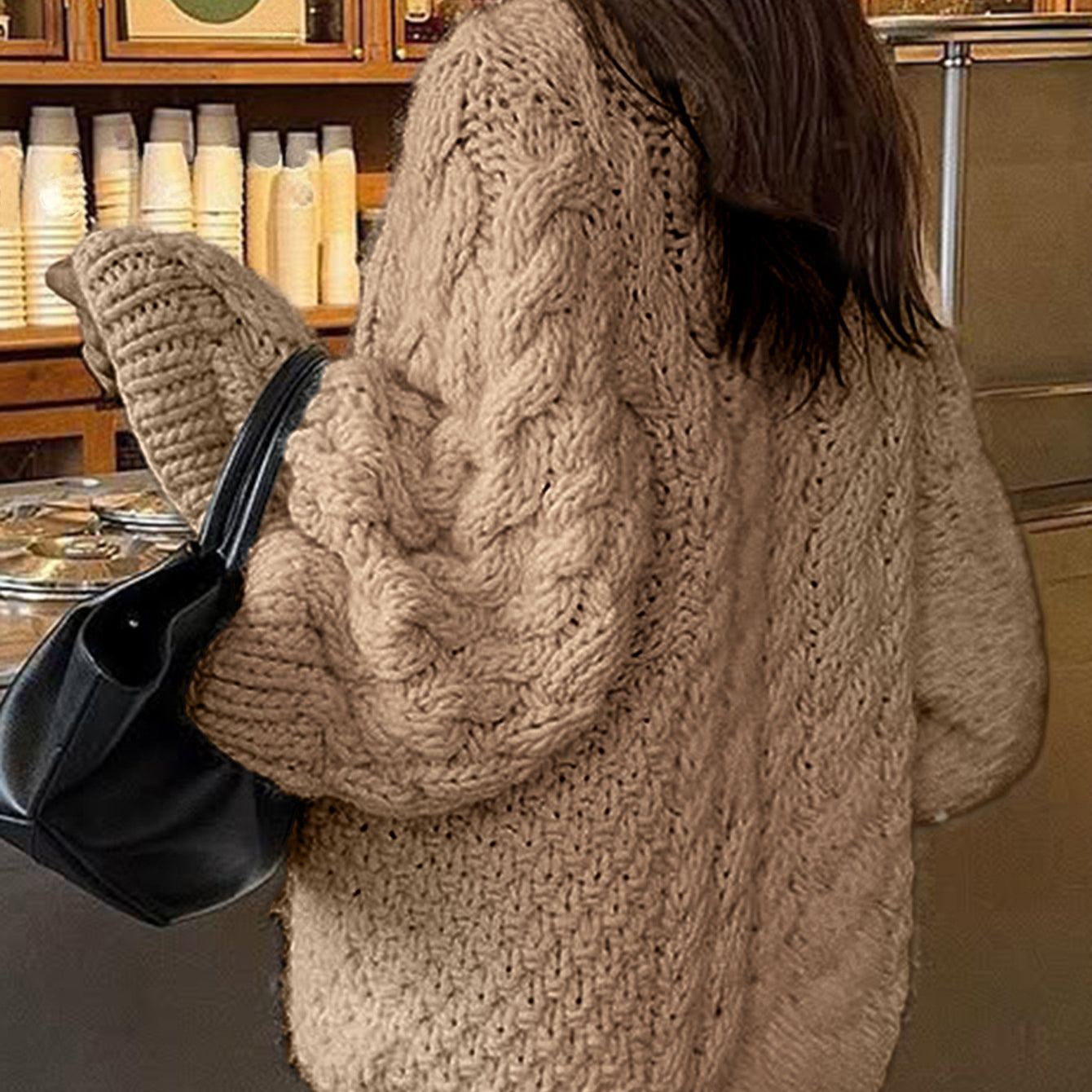 Beige cable knit long sleeve oversized cardigan with black leather tote bag