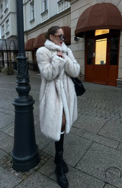 Warm winter faux fur coat with white fur, black trim, and buttons