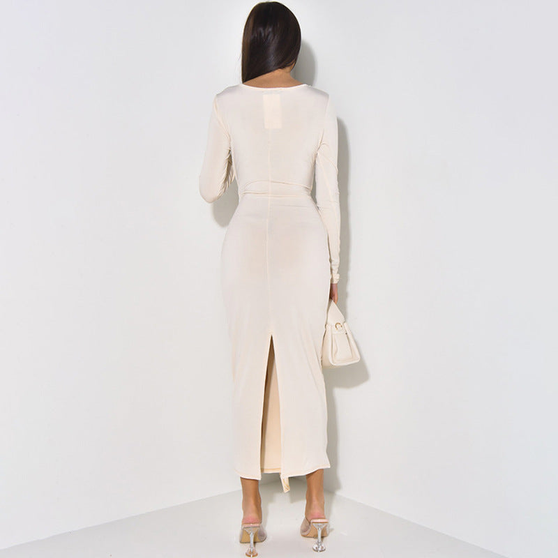 Long-sleeved cream dress with back slit and handbag for elegant fashion ملابس