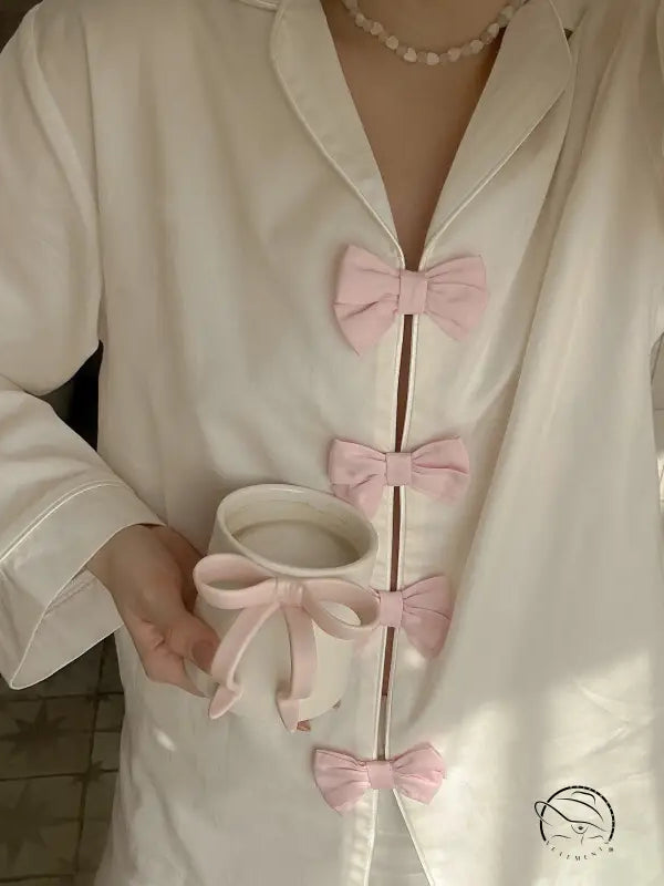 White silk langry fashion pajamas set with pink bow accents and pearl necklace