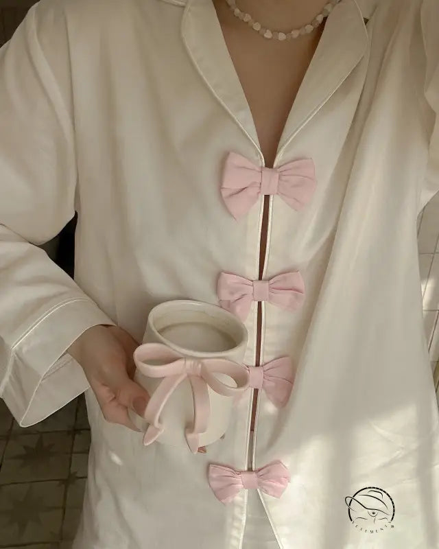 White silk langry fashion pajamas set with pink bow accents and pearl necklace