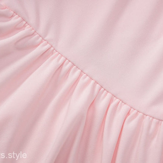 Pink gathered fabric on a sexy halter low cut ruffled dress for elegant evening wear