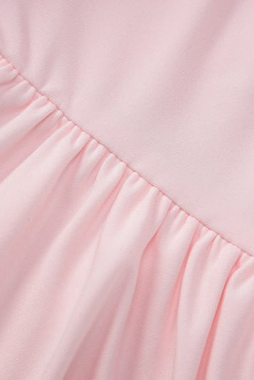 Pink gathered fabric on a sexy halter low cut ruffled dress for elegant evening wear