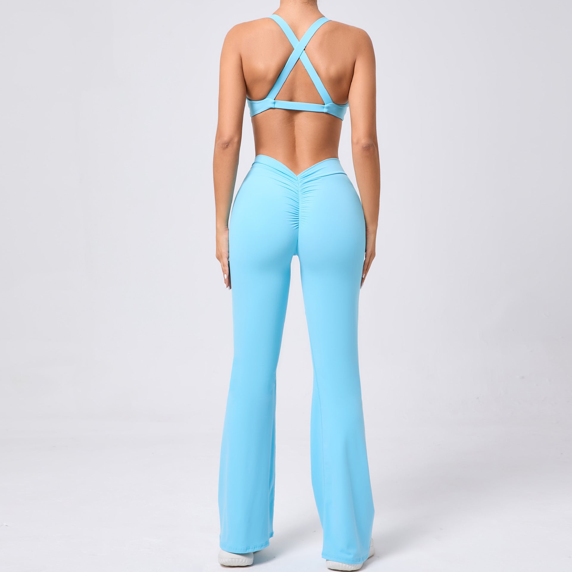 Light blue tight brushed yoga jumpsuit with peach hip raise crisscross back