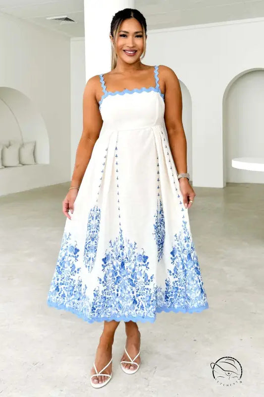 Attractive backless dress in white with blue floral hem and spaghetti straps