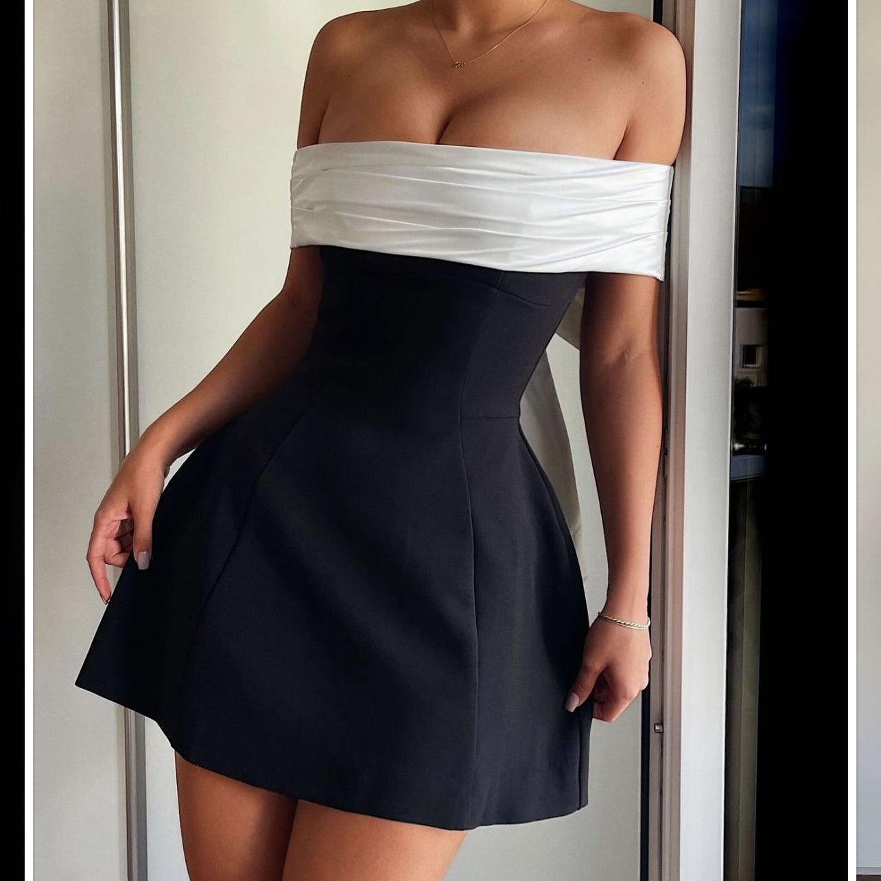 Elegant off-the-shoulder black and white swing dress showcasing fashionable ملابس for stylish women