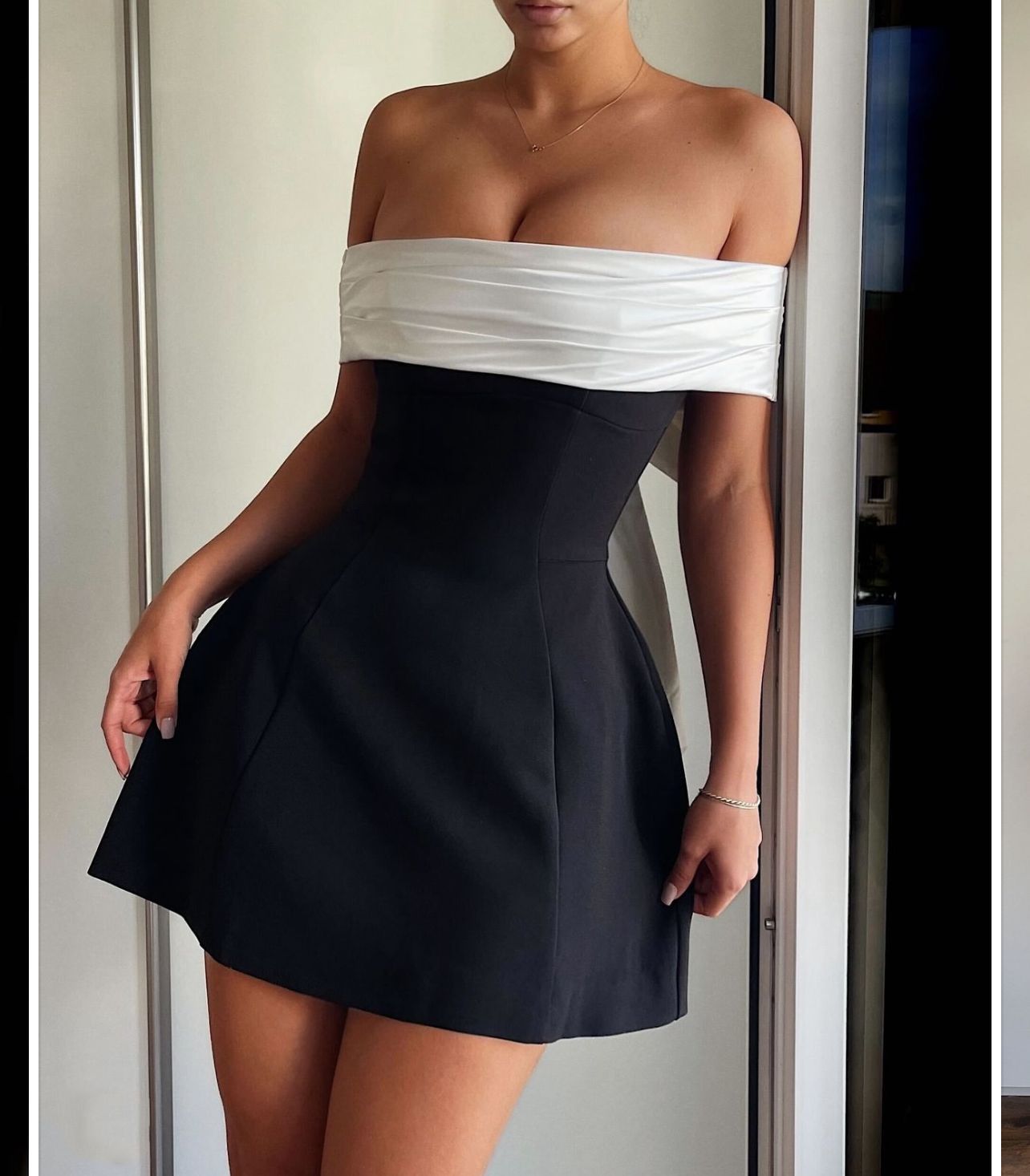 Elegant off-the-shoulder black and white swing dress showcasing fashionable ملابس for stylish women