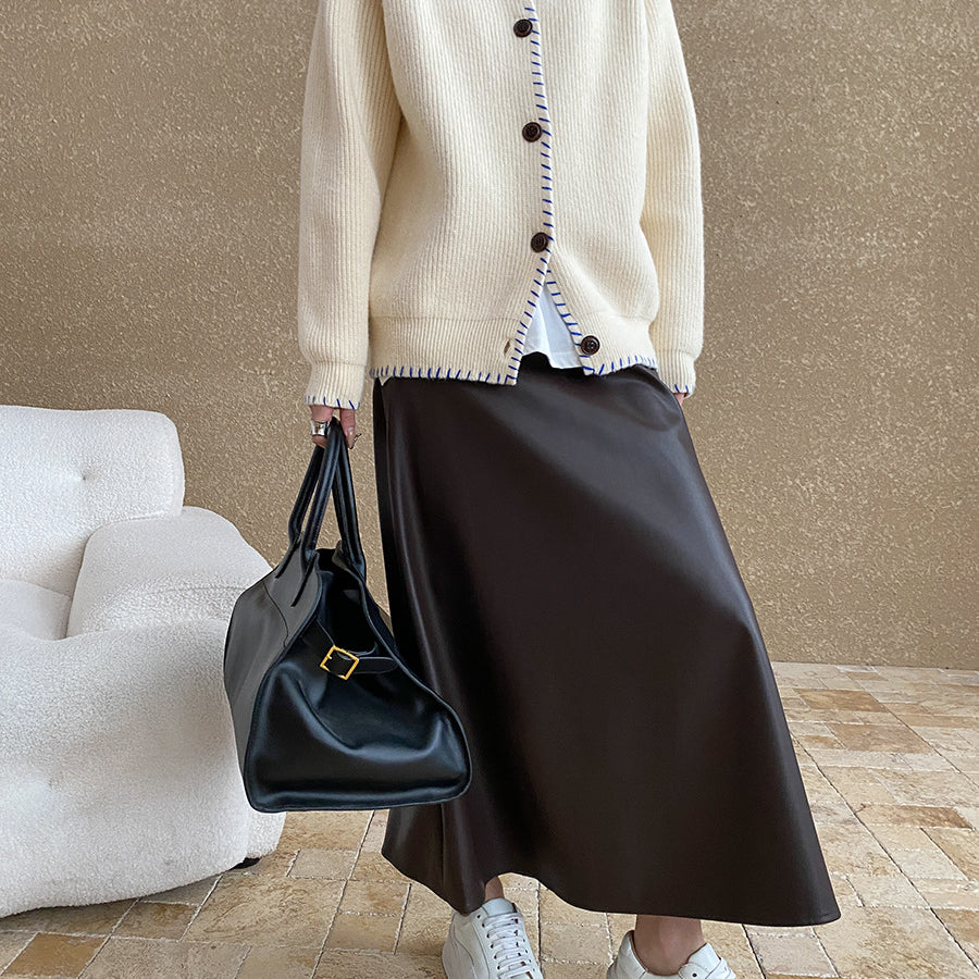 White knit cardigan coat with dark trim, decorative buttons, and regular sleeves in fashion