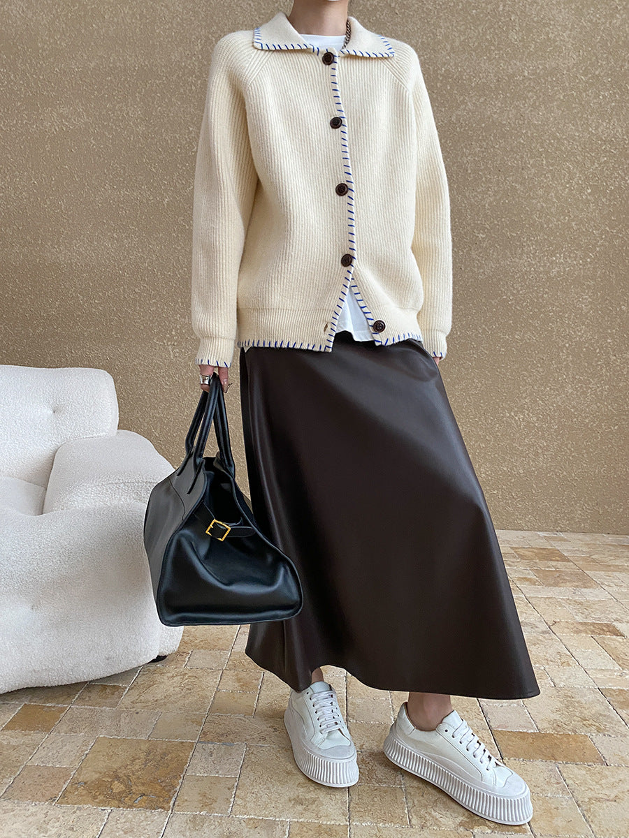 White knit cardigan coat with dark trim, decorative buttons, and regular sleeves in fashion