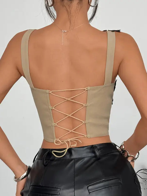 Beige lace-up lace corset top with thin straps and black leather pants