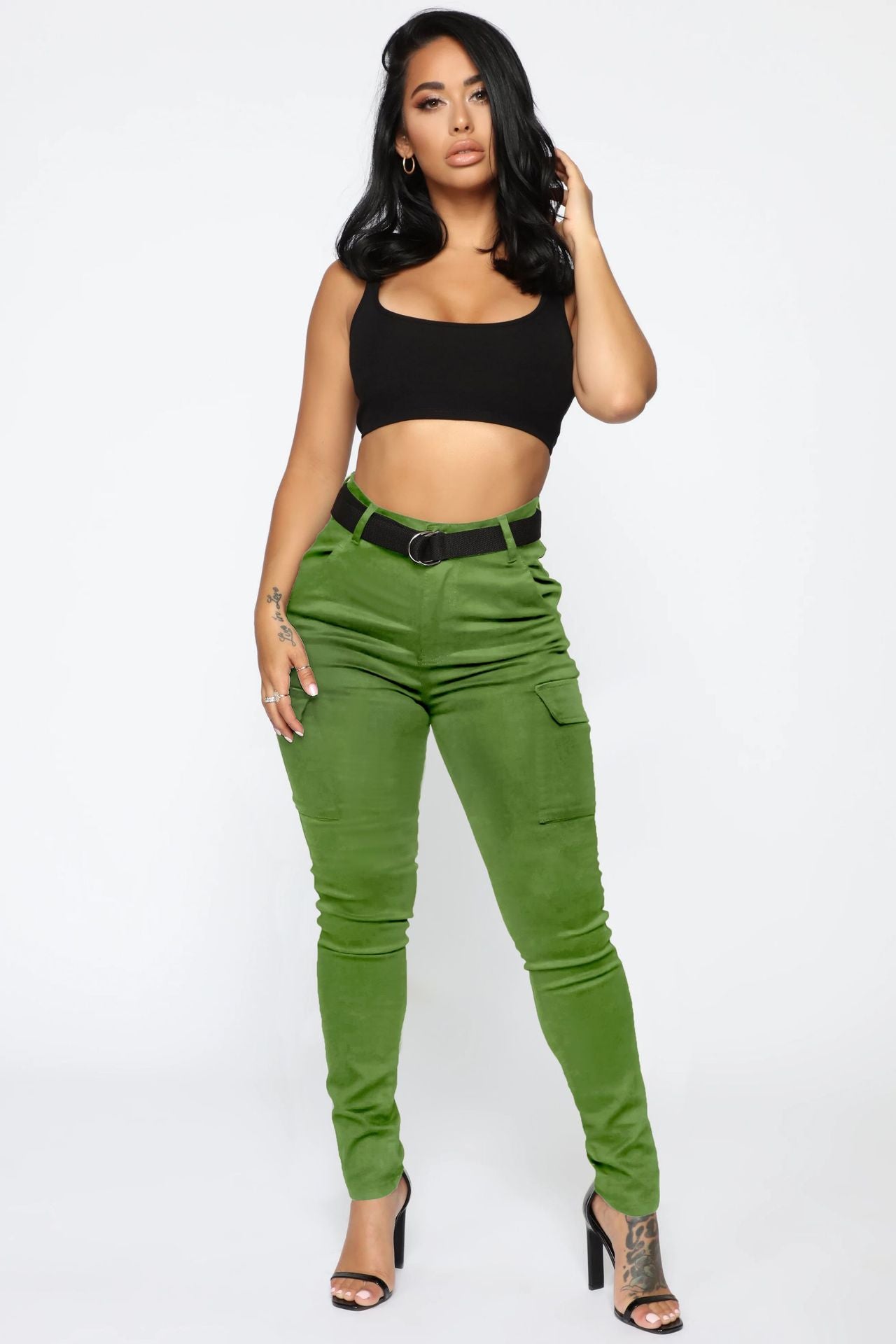 Woman in casual skinny stretch belt sports pants and black crop top showcasing style