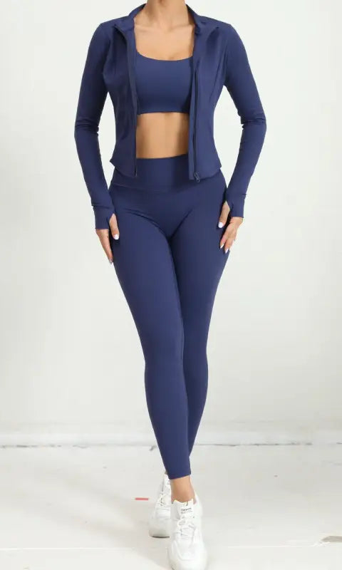 Navy blue three piece yoga clothes suit with cropped top, leggings, and zipper jacket