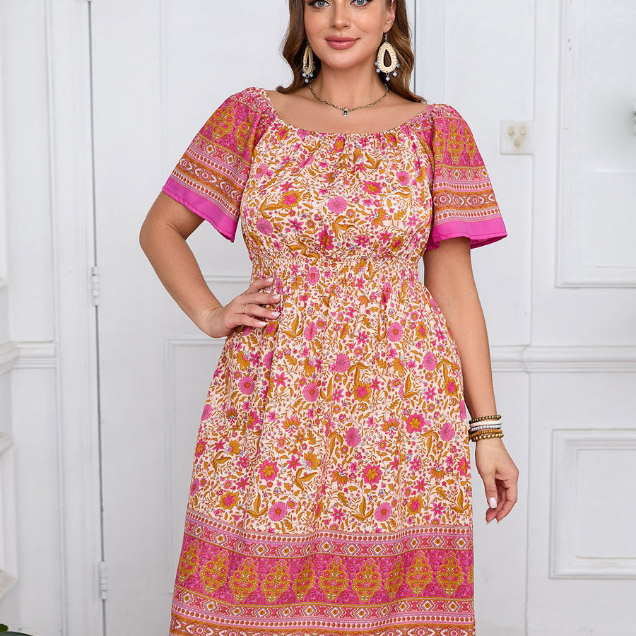 Plus-size elegant bohemian dress with colorful floral border print in shades of pink and orange