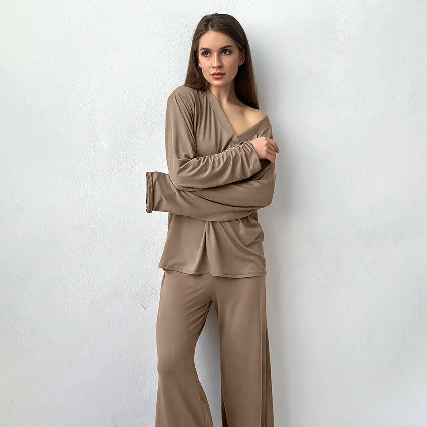 Woman modeling comfortable knitted pajamas with off-the-shoulder top and wide-leg pants in taupe