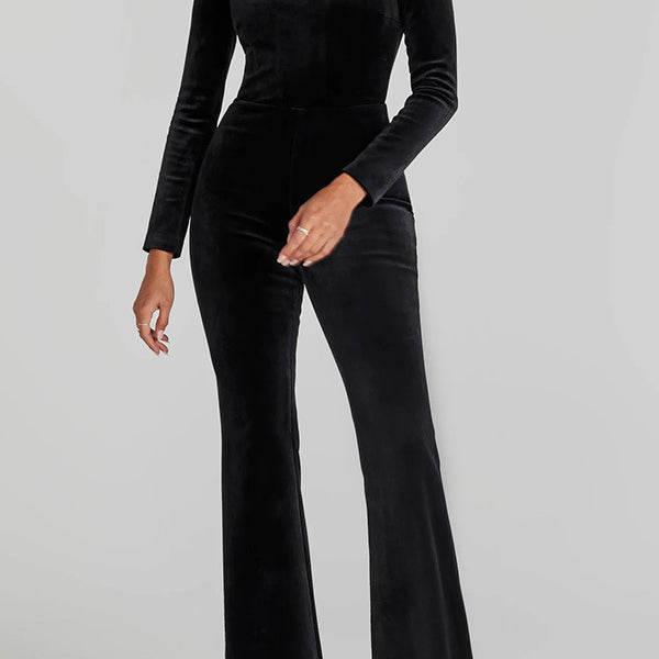 Black velvet jumpsuit with flared legs, long sleeves, and crystal neckline for fashion