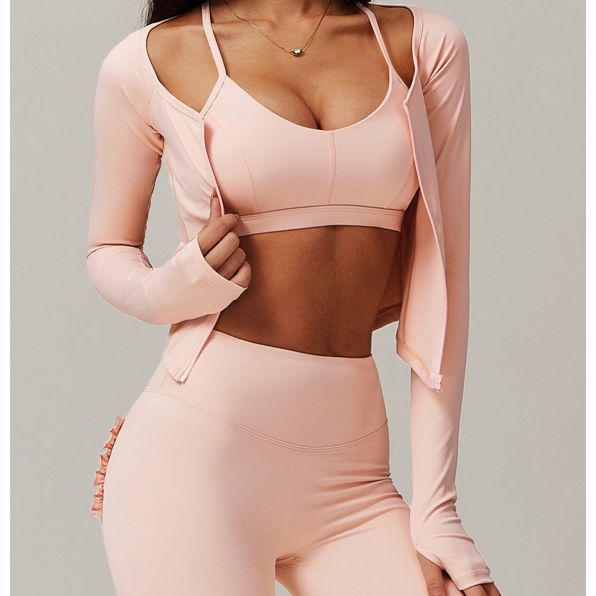 Pink workout set featuring a sports bra, leggings, and zip-up jacket for trendy fitness fashion