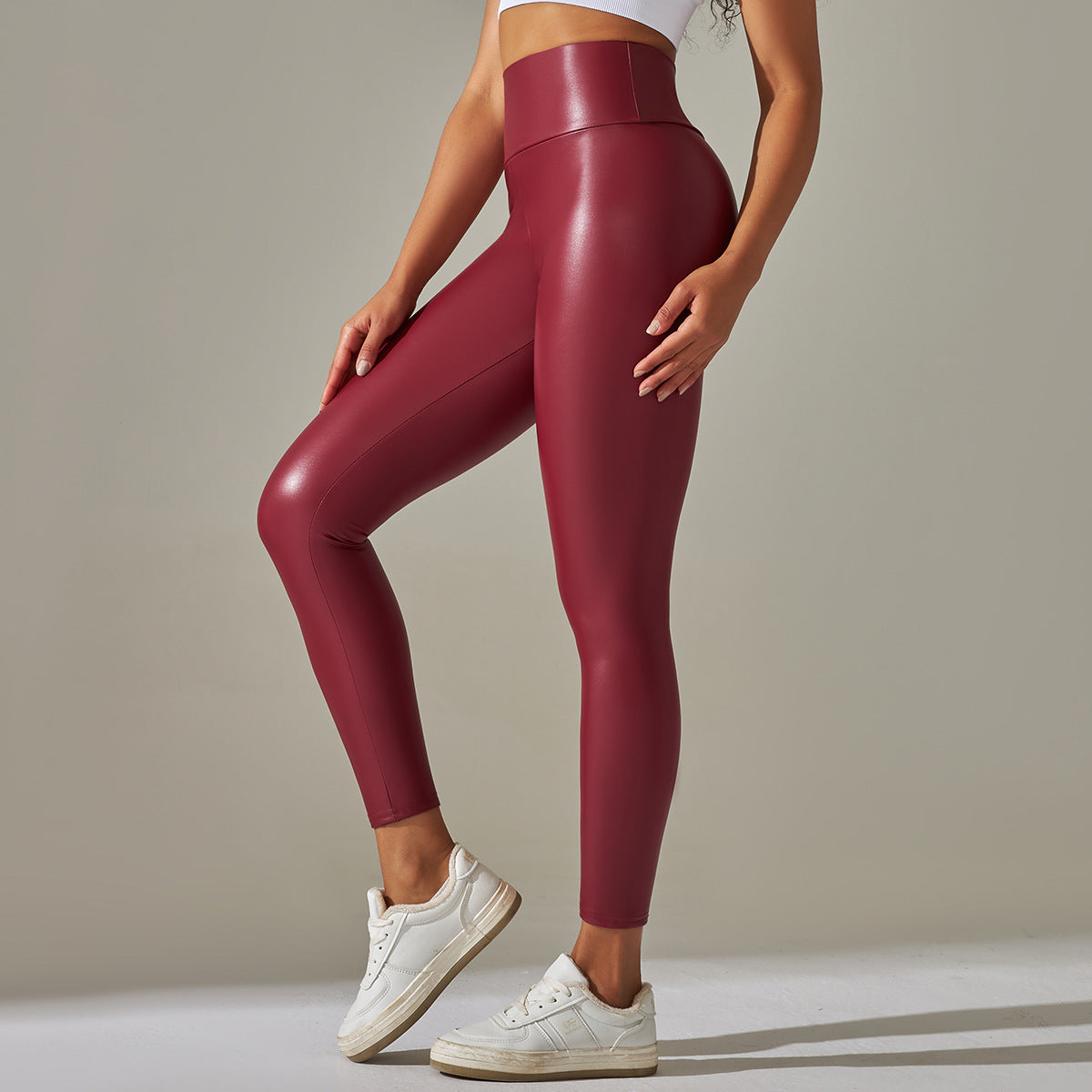 Burgundy high waist faux leather leggings with white sneakers
