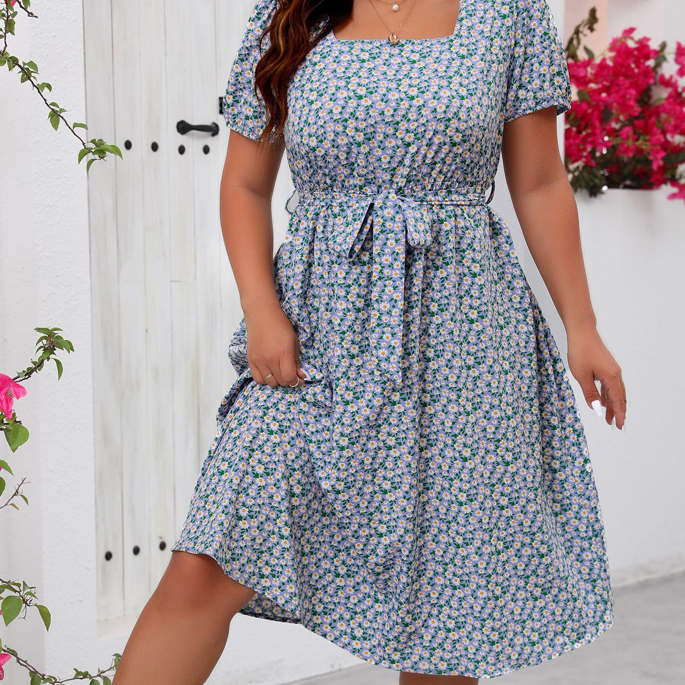 Woman modeling a blue and white floral summer dress with square neckline and puffed sleeves