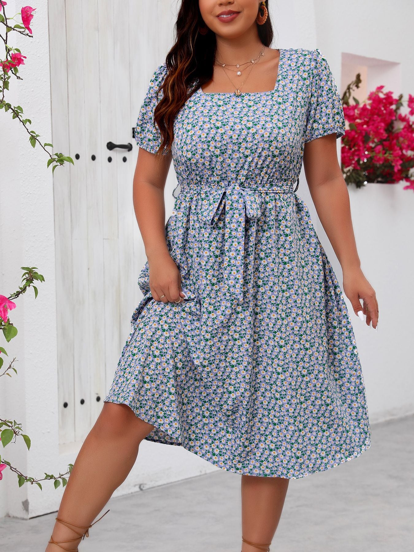 Woman modeling a blue and white floral summer dress with square neckline and puffed sleeves