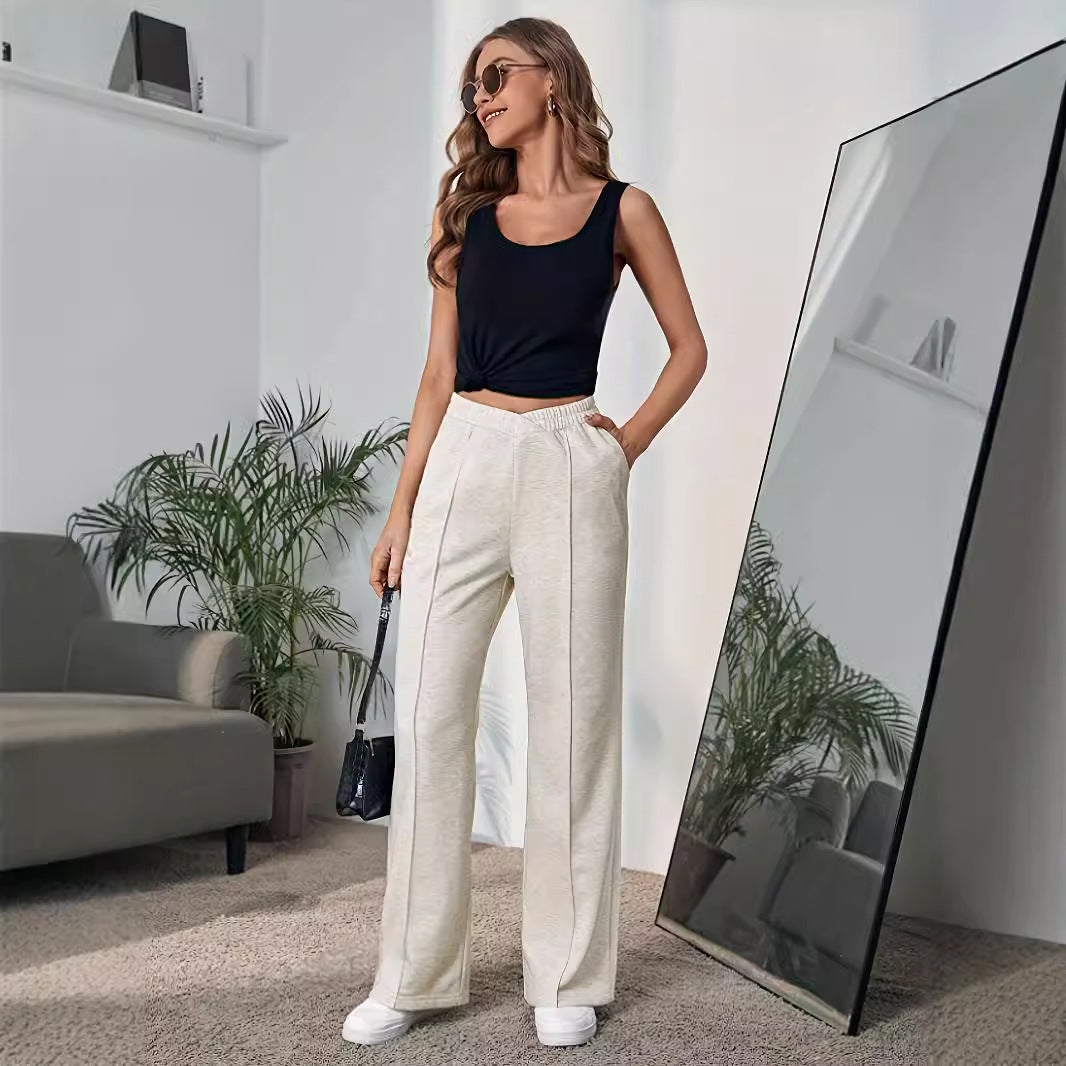 Cream-colored high-waisted wide leg pants styled with a black crop top for elegant fashion