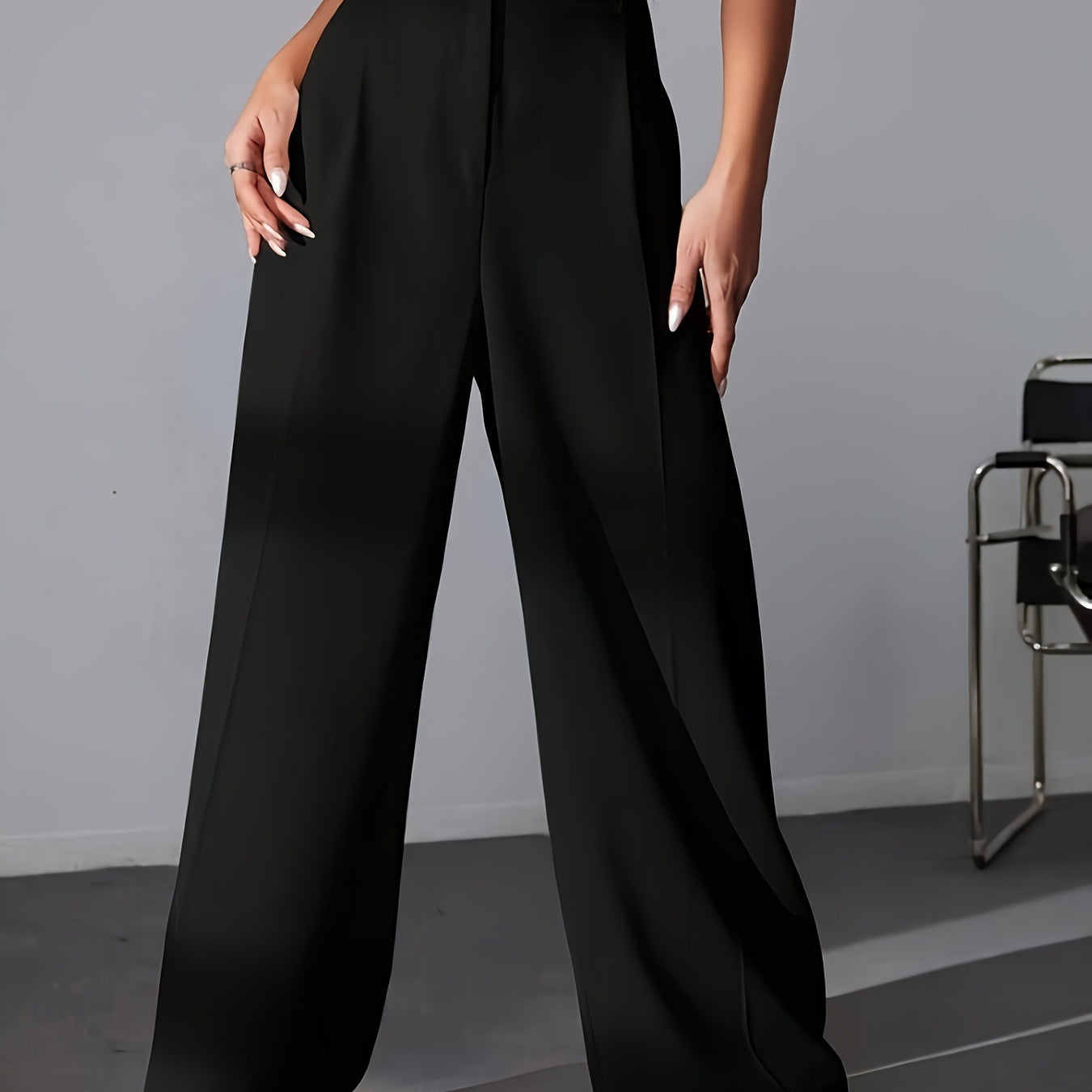 Black high-waisted wide leg trousers with white sneakers for a stylish fashion look