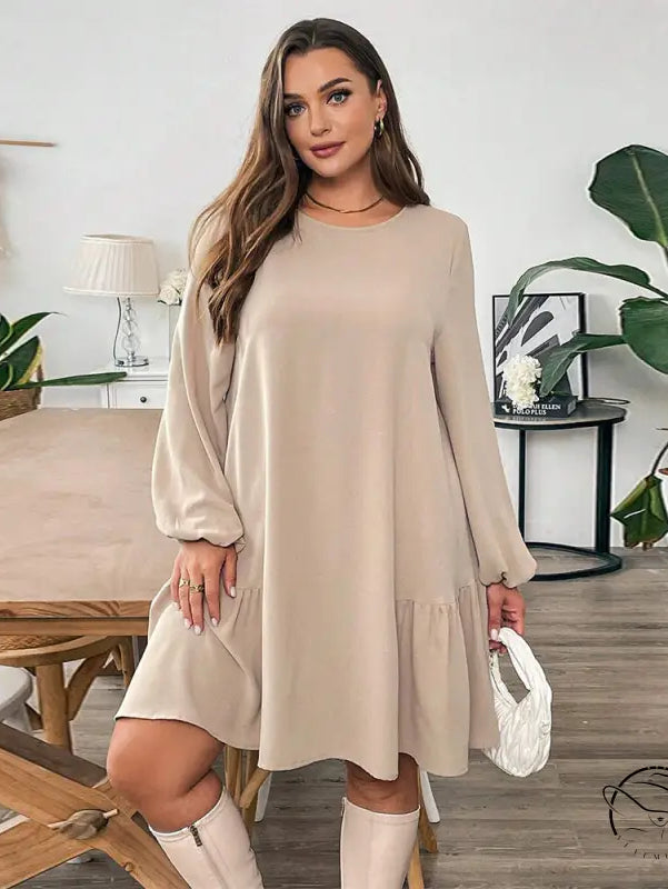 Woman in comfortable winter midi dress with beige long-sleeved tiered ruffle hem