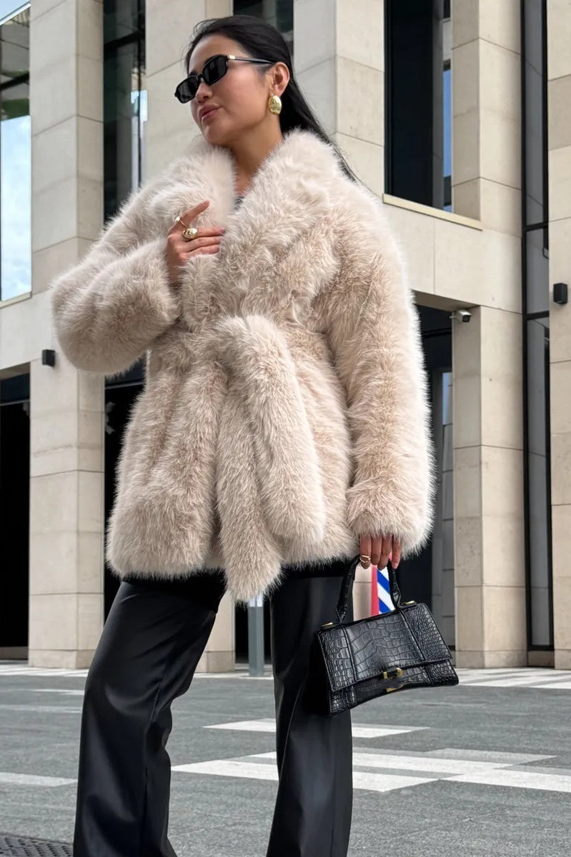 Beige fluffy faux fur coat with black sunglasses and handbag