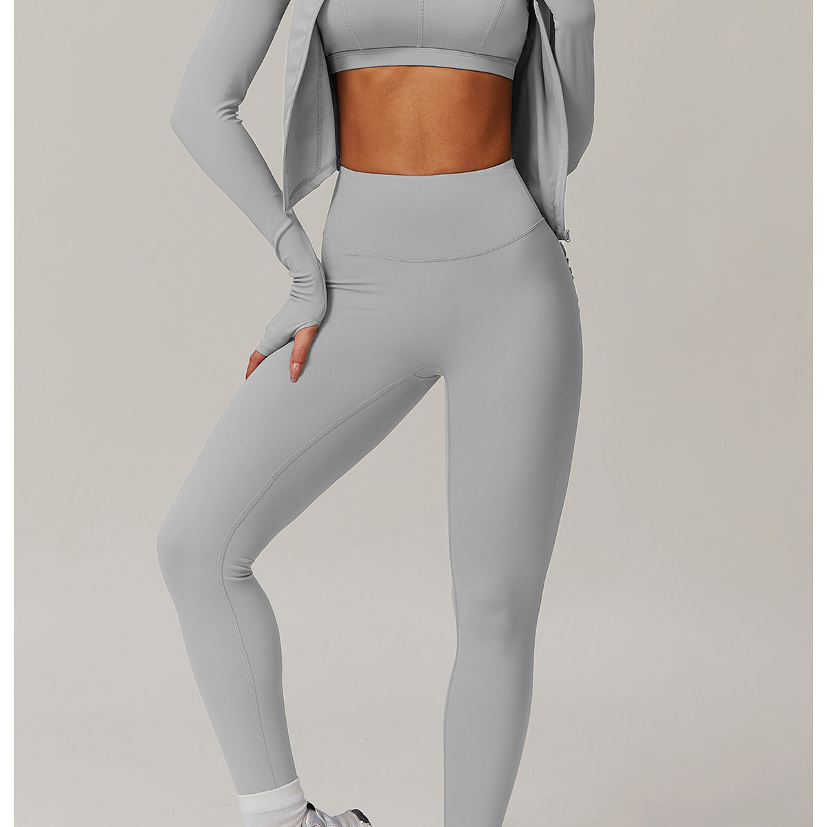 Light grey workout set including sports bra, leggings, jacket, and white sneakers for yoga fashion