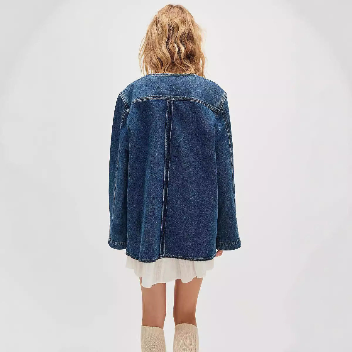 Woman from behind wearing casual fashionable cowboy coat with denim jacket and ruffled dress