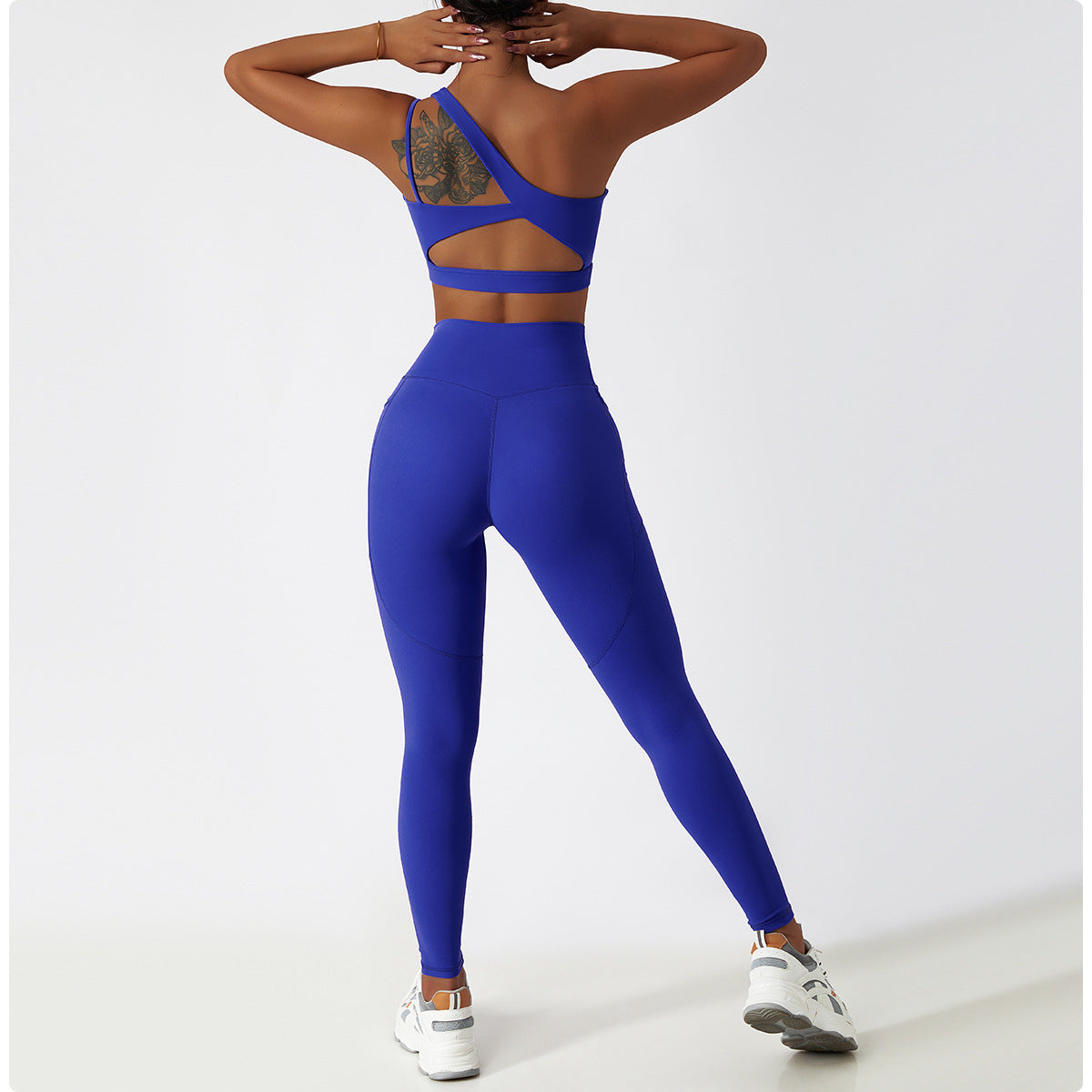 Royal blue langry workout jumpsuit with strappy back and white sneakers for fashion enthusiasts