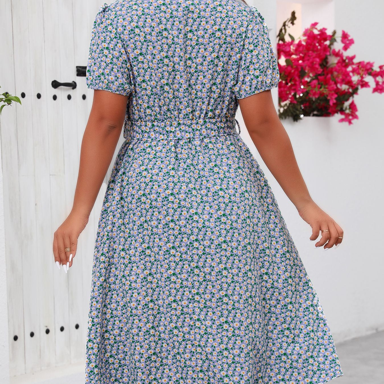 Woman wearing a green floral summer dress with tie waist, perfect for summer outings