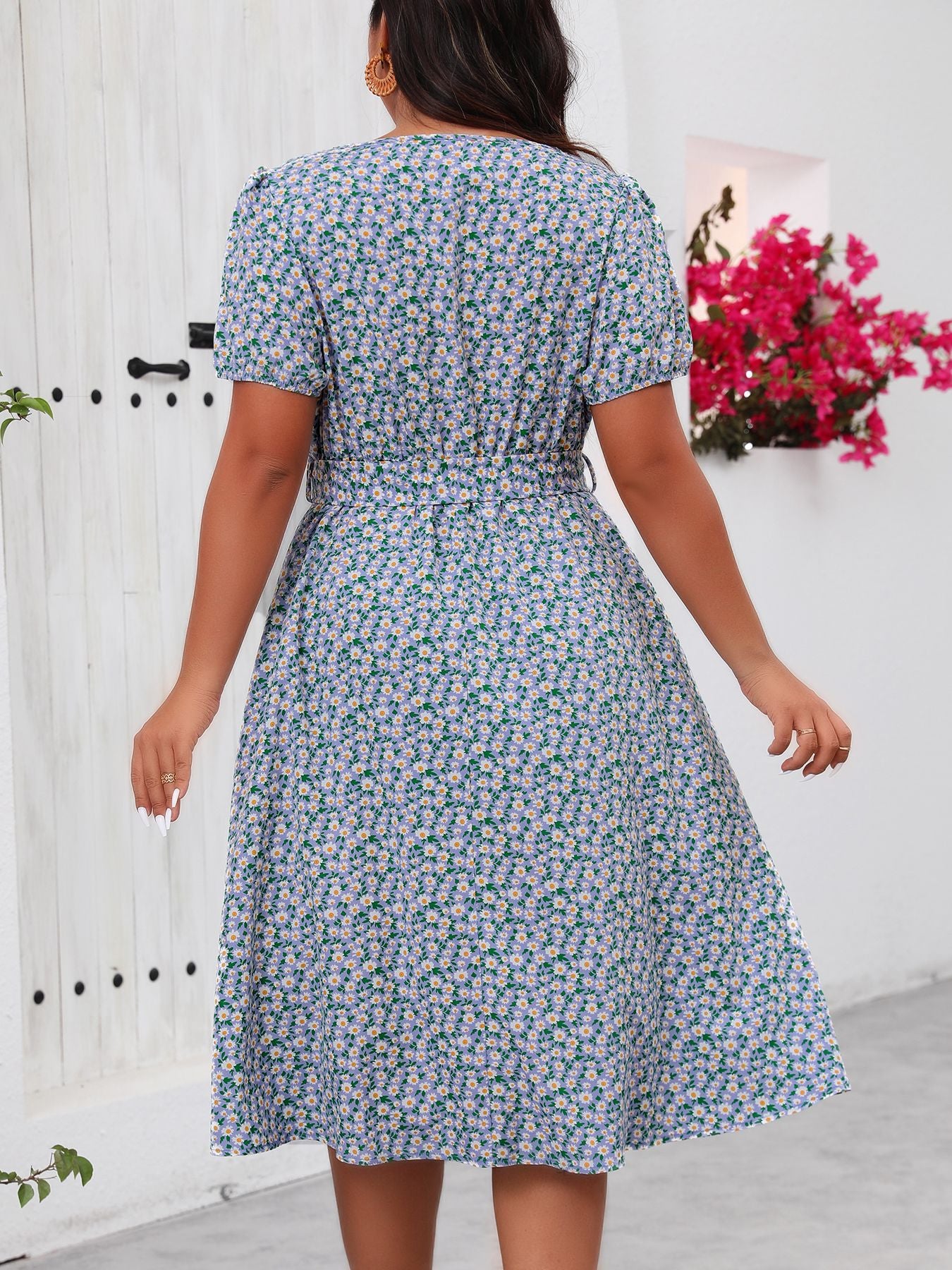 Woman wearing a green floral summer dress with tie waist, perfect for summer outings