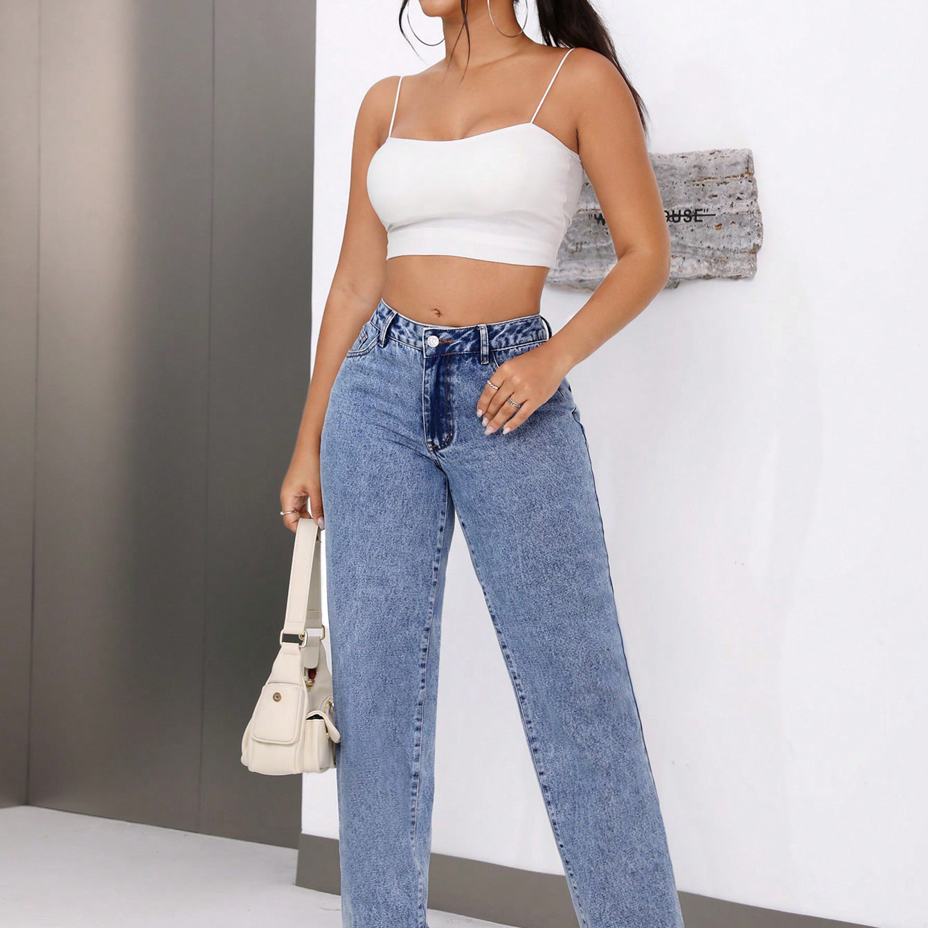 Woman wearing high waist retro straight leg denim trousers in white crop top