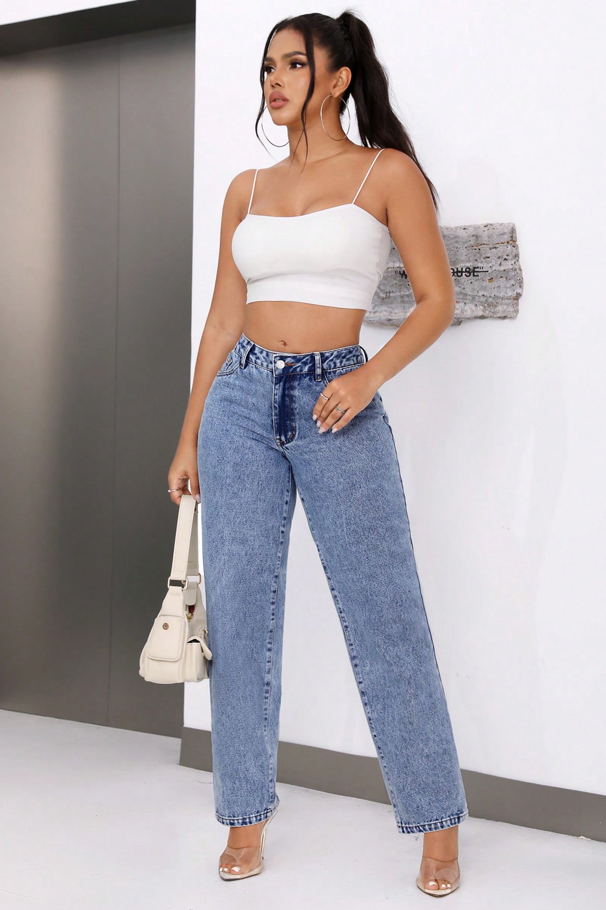 Woman wearing high waist retro straight leg denim trousers in white crop top