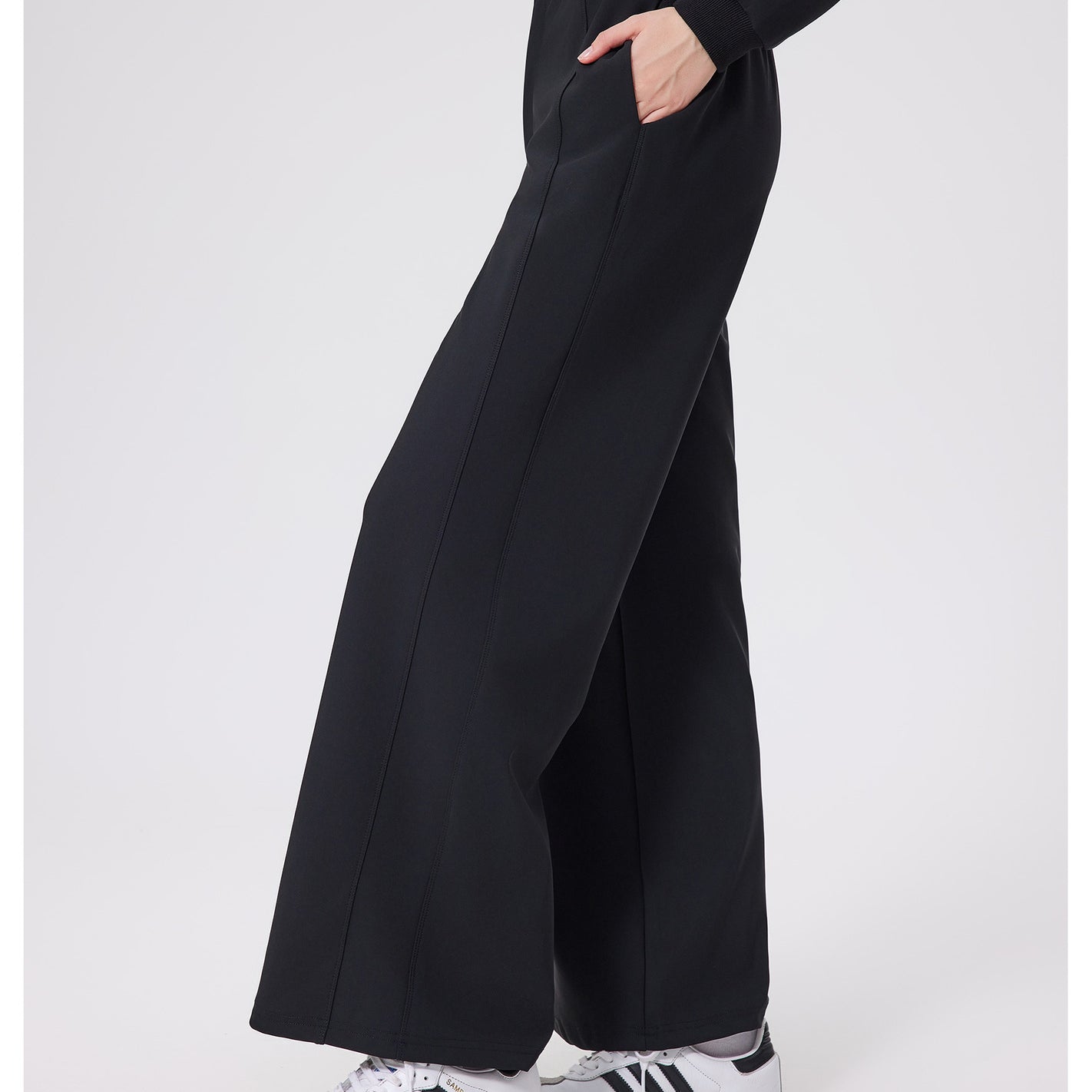 Black loose fitness warm pants with white Adidas sneakers and gold zipper detail