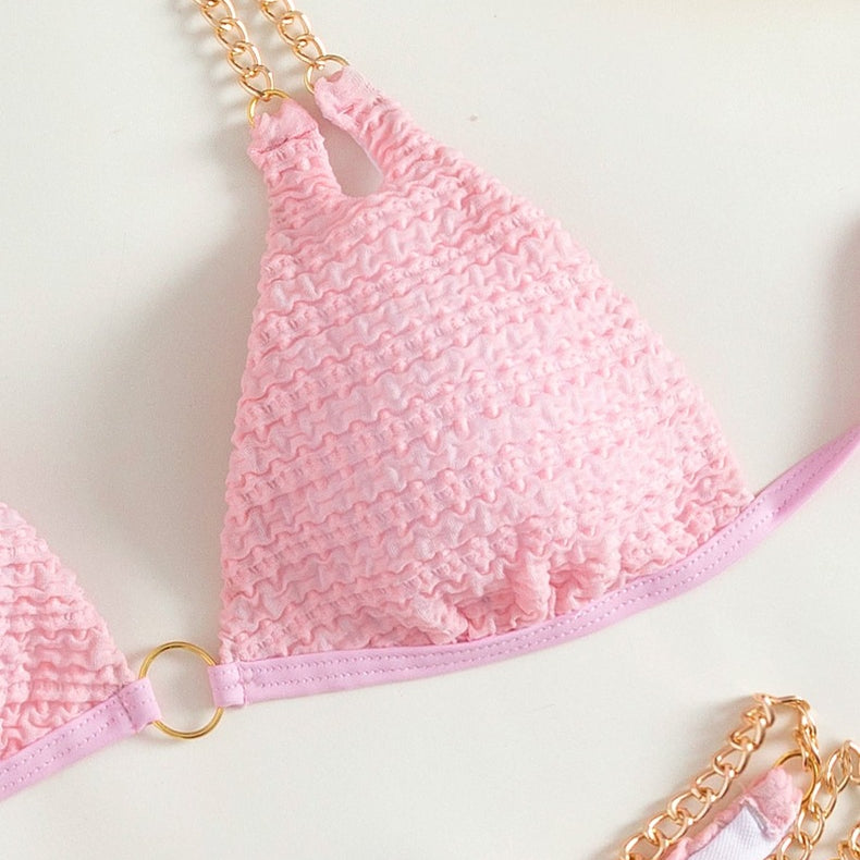 Pink textured bikini top with gold chain straps from the Backless Split Swimsuit collection