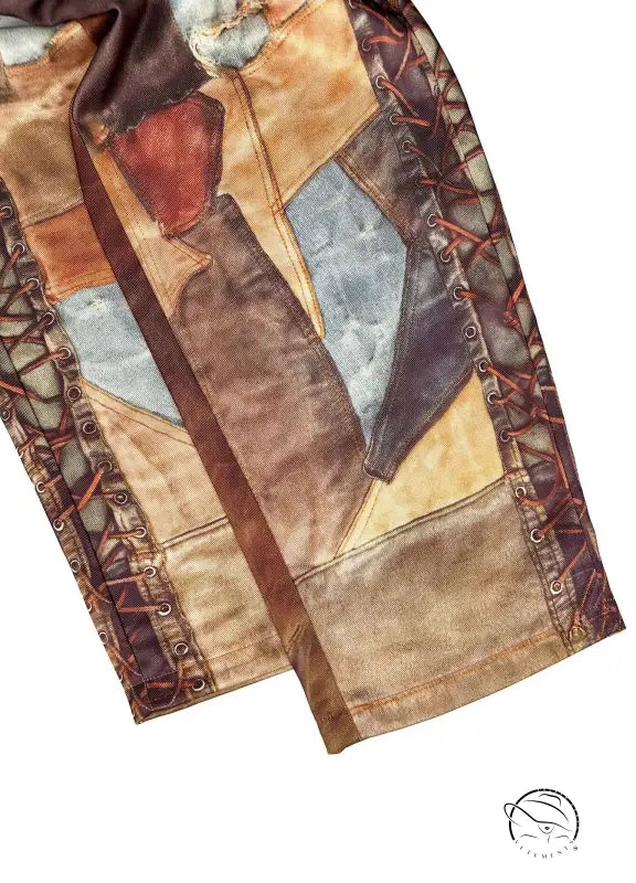 Patchwork leather jacket sleeve with brown, tan, blue geometric panels on casual dirty denim pants