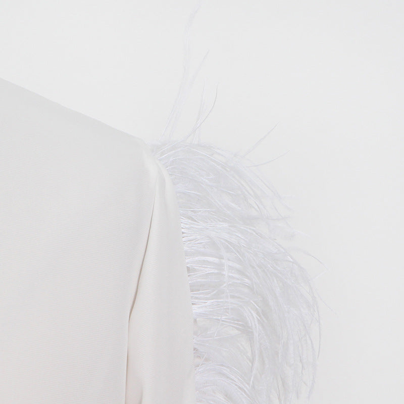White long sleeve garment with elegant ostrich feather embellishments for sophisticated fashion