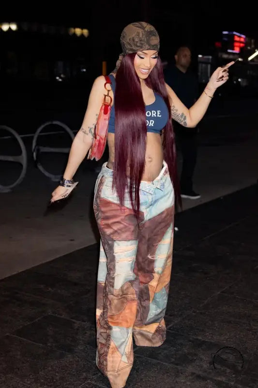 Person in casual dirty denim pants, crop top, and long purple hair