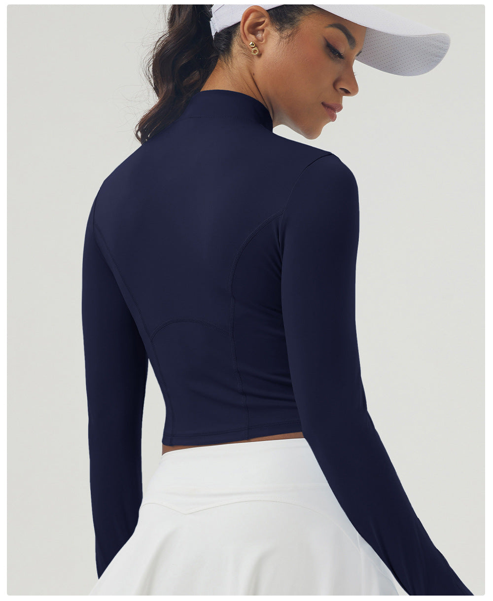 Navy blue long sleeve athletic top with mock neck, paired with white pleated skirt for women