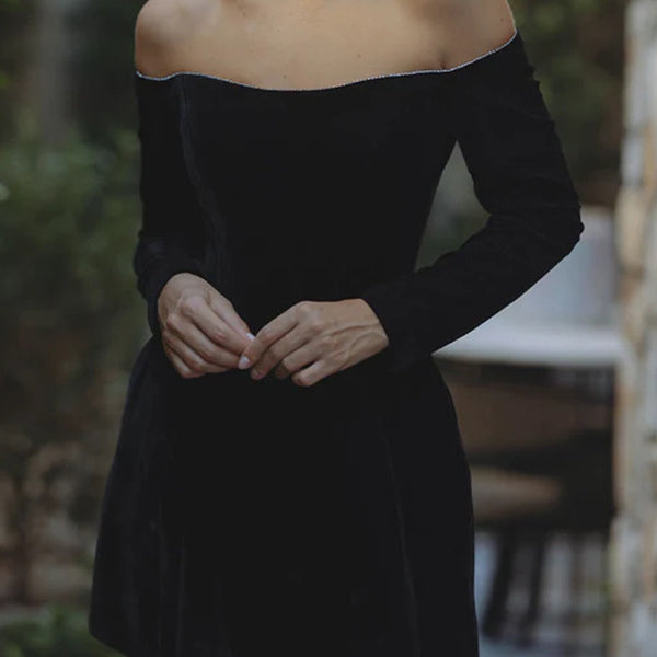 Elegant off-shoulder black mini dress with long sleeves, perfect for stylish fashion lovers