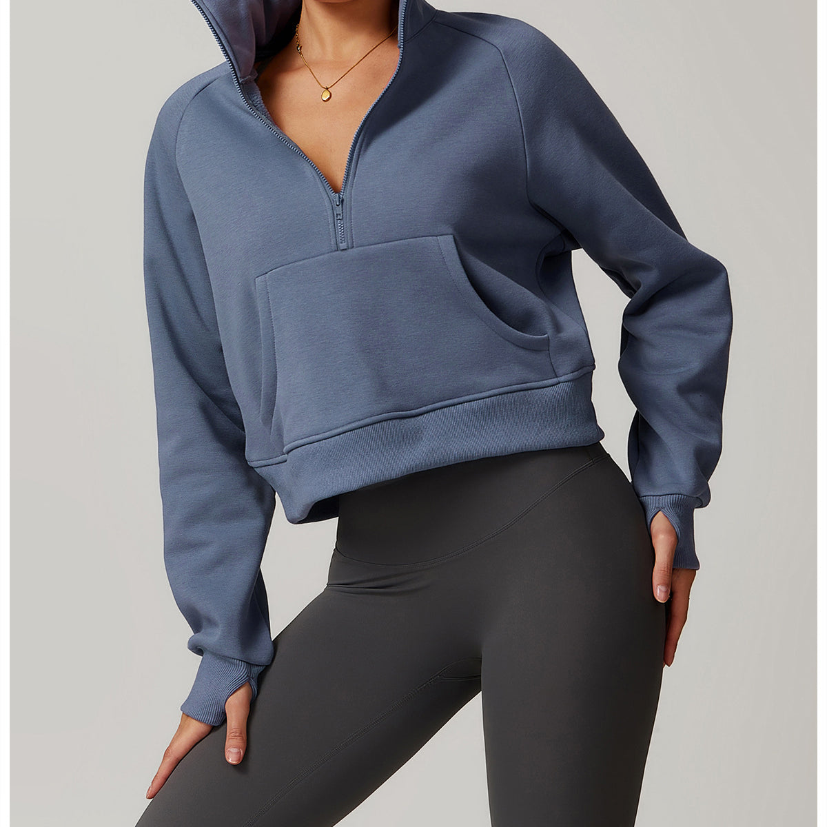 Cropped blue-gray quarter-zip sweatshirt with front pocket, paired with black leggings for langry fashion