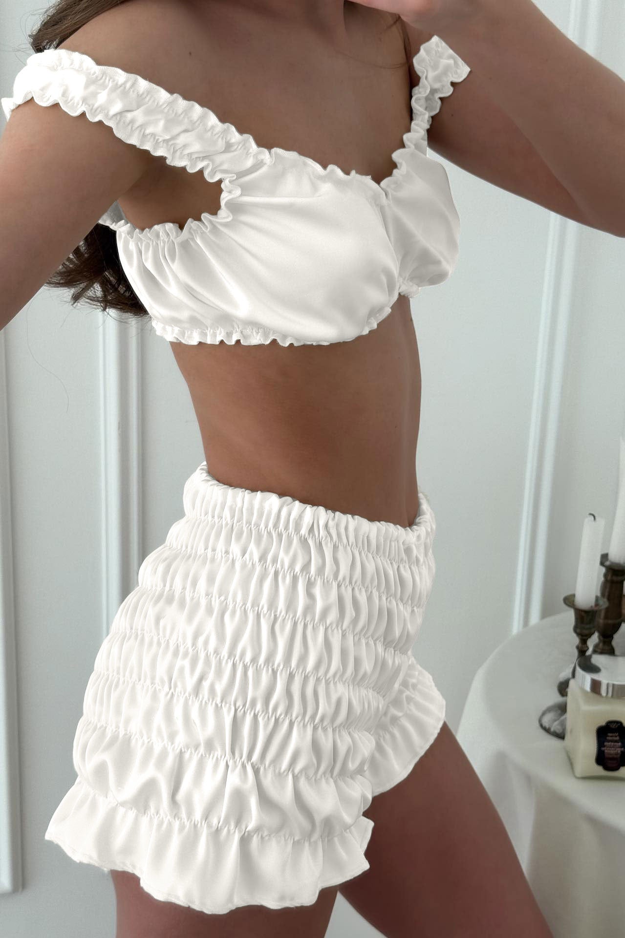 White ruffled off-shoulder pleated satin top and shorts set with lace trim